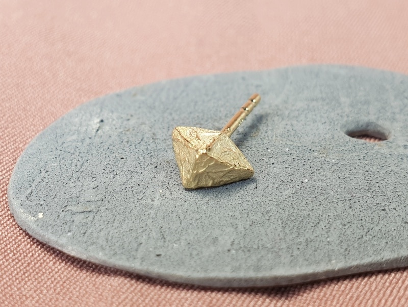 Geelgouden oorbel 'Kristallen'. Stoere hoekige vorm. Enkele oorbel. Ontwerp van oogst Sieraden in Amsterdam.