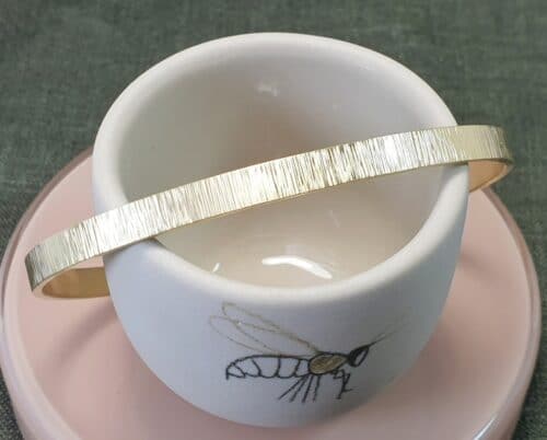Geelgouden klemarmband Ritme met een bruine diamant. Ontwerp van Oogst goudsmeden in Amsterdam.