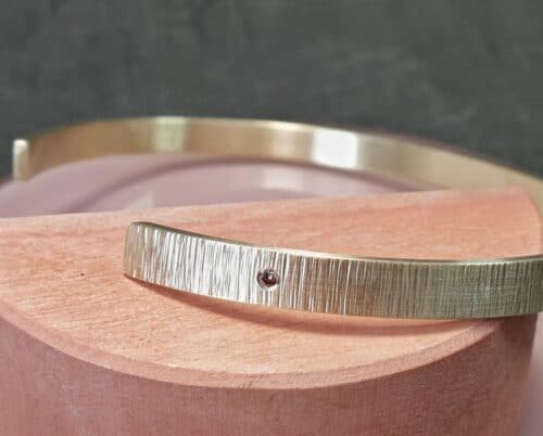 Geelgouden klemarmband Ritme met een bruine diamant. Ontwerp van Oogst goudsmeden in Amsterdam.