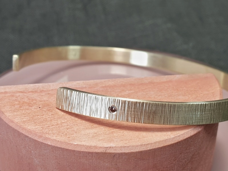 Geelgouden klemarmband Ritme met een bruine diamant. Ontwerp van Oogst goudsmeden in Amsterdam.