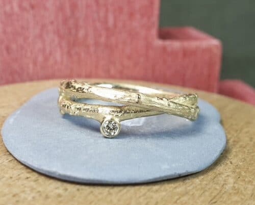 Geelgouden ring uit de Boomgaard serie, overkruist takje met diamant. Ontwerp van Oogst Sieraden in Amsterdam