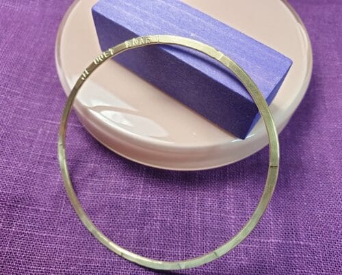 Geelgouden rinkel armband met tekst. Gedenksieraad, maatwerk armband van Oogst Sieraden in Amsterdam