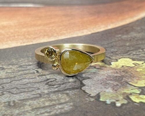 Ring 'Verzameling'van eigen goud vervaardigd met spitse hamerslag en een 1,21 ct mosterd natural diamant en een 0,10 ct briljant geslepen diamant olijf. Maatwerk uit het Oogst atelier in Amsterdam.