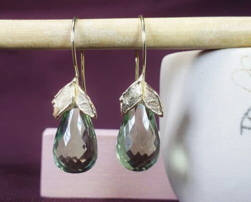 Geelgouden oorsieraden van blaadjes met briolet geslepen prasioliet. druppels. Ontwerp van Oogst Sieraden in Amsterdam.
