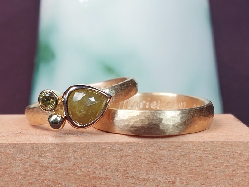 Hammered wedding rings 'Cluster & Rhythm' in rosé gold. With a pear shaped natural fancy diamond and a brilliant cut diamond olive. Oogst Originals.