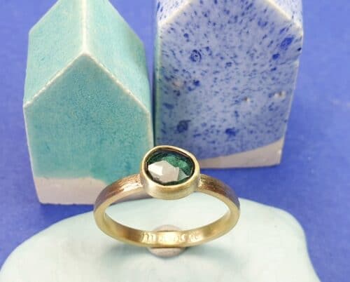 Gedenksieraad. Ring 'Ritme' 14 krt geelgouden ring met spitse hamerslag en 0,61 ct free from roosgeslepen Topaas waar as onder bewaard wordt. Maatwerk van Oogst Sieraden in Amsterdam