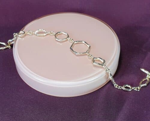 Armband 'Amorf vs Kristallijn': Van eigen goud vervaardigde schakelarmband met 10 handgemaakte schakels, verlopend van vorm, en een kapittel stokje. Uit het Oogst atelier in Amsterdam