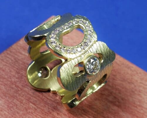 Geelgouden ring Amorf met roze diamant rondom. Open vormen met spitse hamerslag en sprankelende diamanten. Eenmalig ontwerp van Oogst Sieraden.