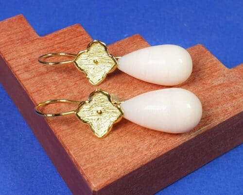 Geelgouden Kamon oorbellen met roze opaal. Maatwerk variatie op de Oogst collectie met haar lievelingskleur edelsteen. Oogst goudsmid atelier.