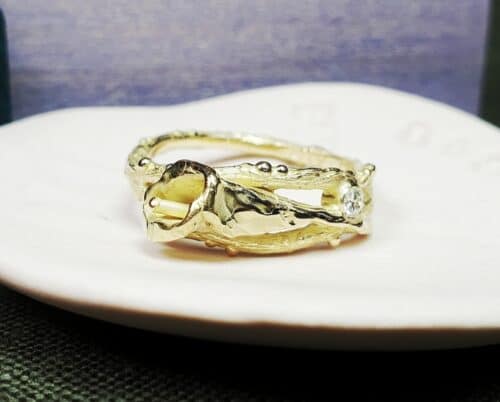 Gedenksieraad. Assieraad. Geelgouden ring Calla Lelie. Takjes met besjes en bloem en een diamant. Maatwerk gedenksieraad. Ontwerp van Oogst Goudsmeden in Amsterdam.