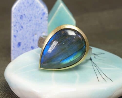 Zilveren ring Ritme met druppel vorm Labradoriet in geelgoud gezet. Ontwerp van Oogst Sieraden. Maatwerk.