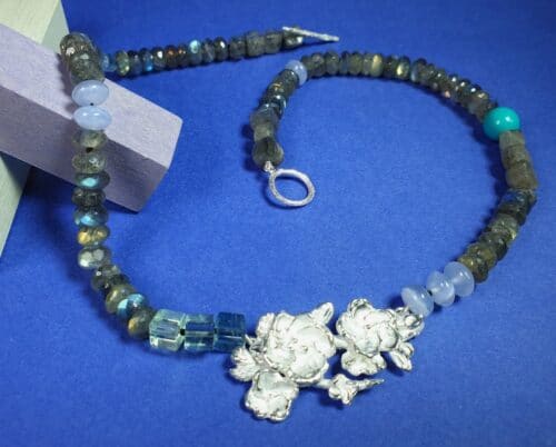 Zilveren collier van bloesemtakje met labradoriet aquamarijn chalcedoon turkoois & fluoriet. Uit de Japonais serie van Oogst Goudsmeden in Amsterdam.