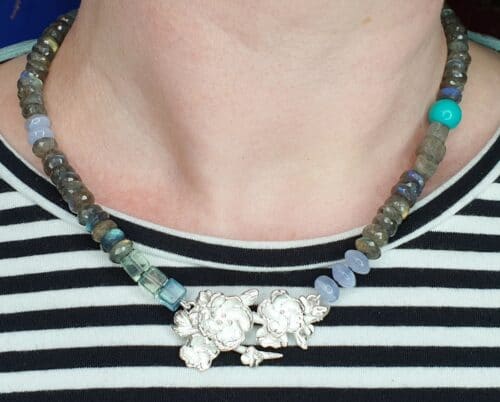 Zilveren collier van bloesemtakje met labradoriet aquamarijn chalcedoon turkoois & fluoriet. Uit de Japonais serie van Oogst Goudsmeden in Amsterdam.