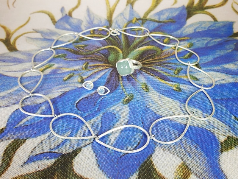 Zilveren Druppel collier, strakke aquamarijn ring en bijpassende zilveren oorsieraden met aquamarijn. Maatwerk ontwerp van Oogst Sieraden in Amsterdam
