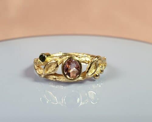 Geelgouden Boomgaard ring met roze en zwarte toermalijn en blaadjes. Maatwerk voor Annaleid van Oogst goudsmid in Amsterdam