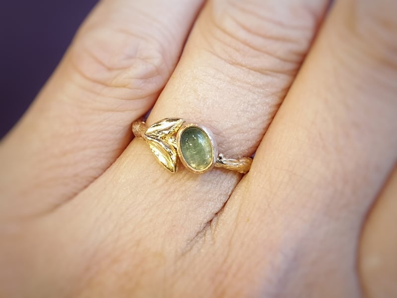 Golden ring with tourmaline and cute leaves from the ‘Orchard’ series. Design by Oogst Jewelry in Amsterdam. Ring on the finger.