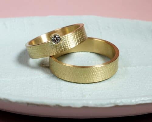 Trouwringen 'Linnen'. Geelgouden ring met 0,10 crt diamant en fijne structuur. Strak ontwerp van Oogst in Amsterdam.