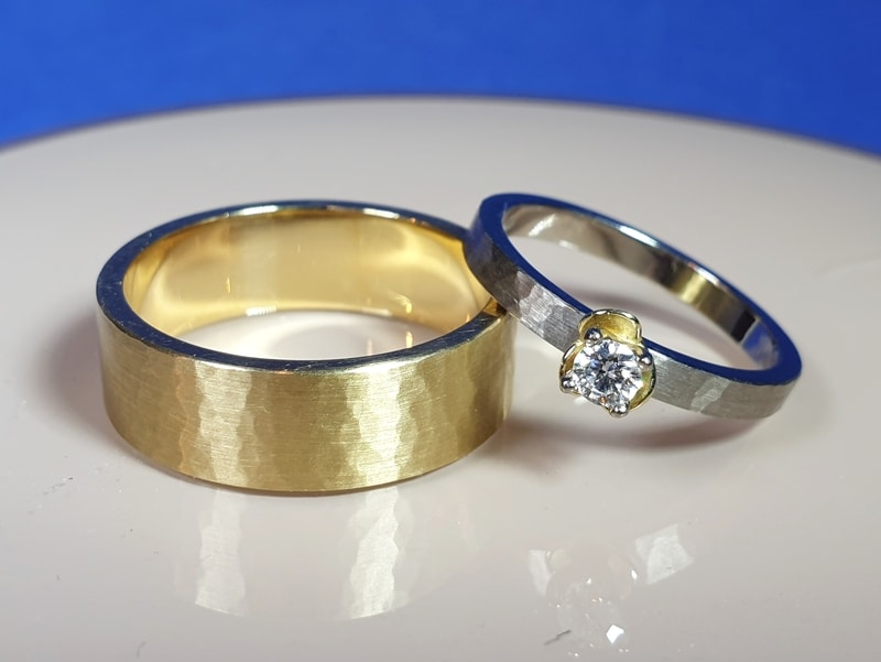 Handgemaakte trouwringen 'Ritme'. Geelgouden trouwring met hamerslag. Witgouden trouwring met hamerslag en diamant. Uit het Oogst atelier.