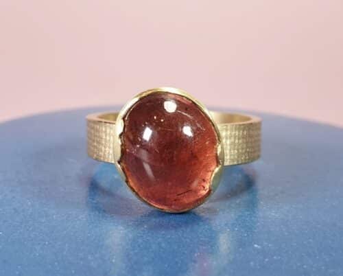 Ring geelgoud met rode Toermalijn in een wolk zetting met een Linnen structuur. Ontwerp van Oogst Sieraden