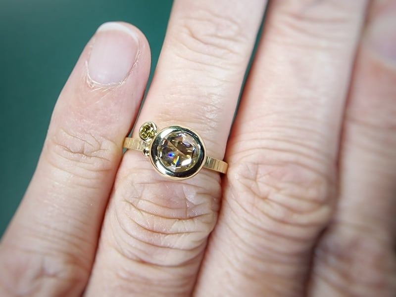 Geelgouden Verzameling ring met een 1,01 ct roosgeslepen diamant en een 0,10 ct briljant geslepen diamant olijf met spitse hamerslag. Ontwerp van Oogst Sieraden in Amsterdam