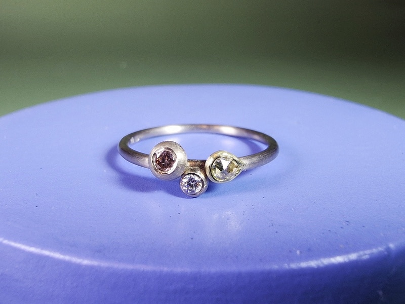 White gold 'Cluster' engagement ring with a playful mix of different cuts and colours diamonds. Design by Oogst goldsmith Amsterdam