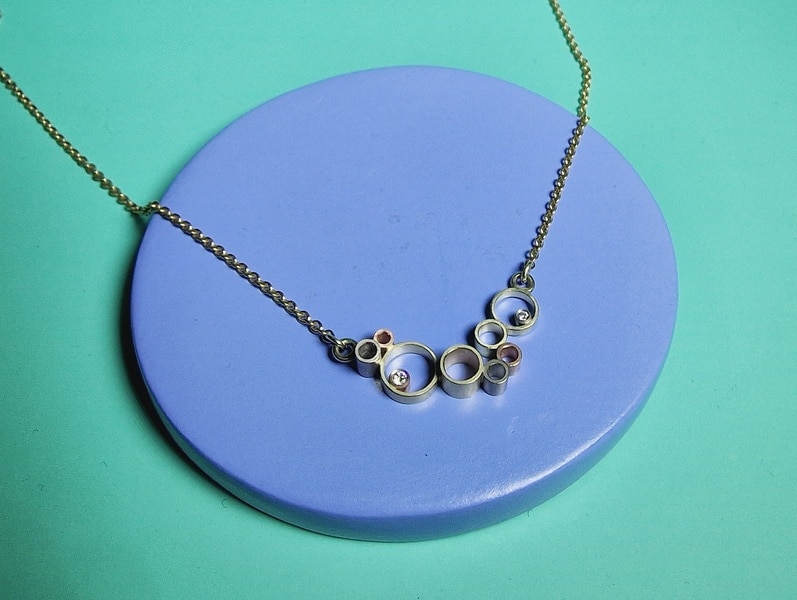 Yellow gold 'Cloud' necklace is made with sleek yellow, rose and white gold shapes and sparkly diamonds. Jewellery design by Oogst, goldsmith in Amsterdam.