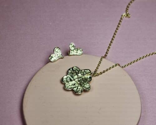 Assieraden hartvormige blaadjes. Geelgouden oorbellen en hanger waar wat as in bewaard wordt. Maatwerk van Oogst Sieraden.