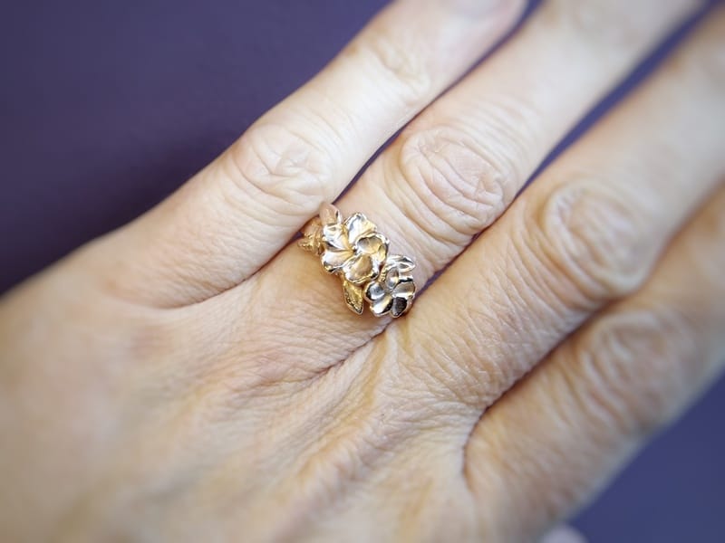 Roodgouden ring bloemen en blaadjes. Uit de japonais serie. Bloesem sieraad. Eenmalig ontwerp van Oogst Goudsmeden in Amsterdam. Ring om vinger.