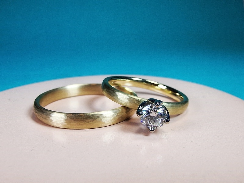 Trouwringen Ritme met streepjes hamerslag geelgoud en briljant geslepen diamant. Ontwerp Oogst edelsmid Amsterdam.