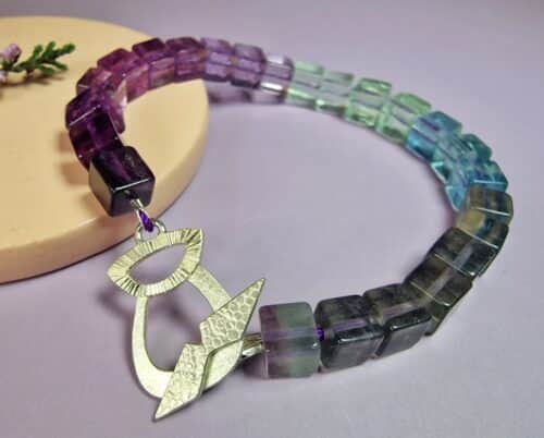 Edelsteen armband fluoriet met zilveren distel, om de pols. Oogst Sieraden in Amsterdam.