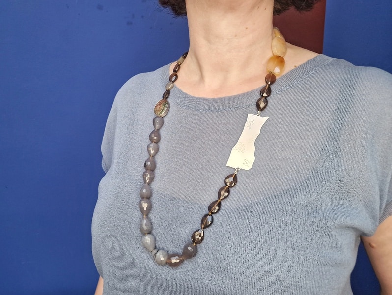 Edelsteen collier met zilveren rotsornament, rutielkwarts, agaat, rookkwarts, saffier, gedragen om hals. Statement ketting van Oogst Goudsmeden in Amsterdam