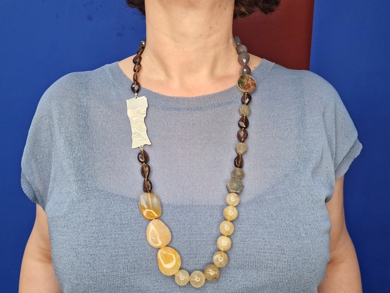 Edelsteen collier met zilveren rotsornament, rutielkwarts, agaat, rookkwarts, saffier, gedragen om hals. Statement ketting van Oogst Goudsmeden in Amsterdam