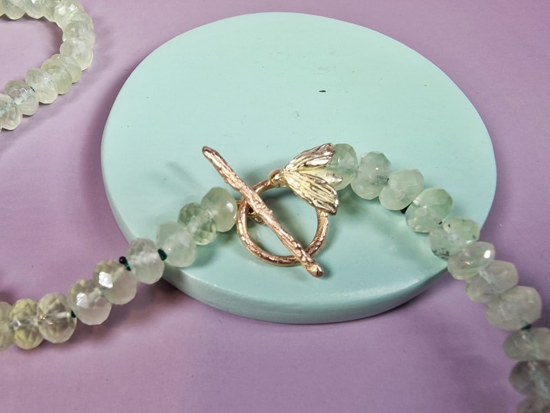 Edelsteen collier prehniet met roodgouden distel met amethist briolet. Detail van de sluiting. Ontwerp van Oogst Sieraden in Amsterdam.