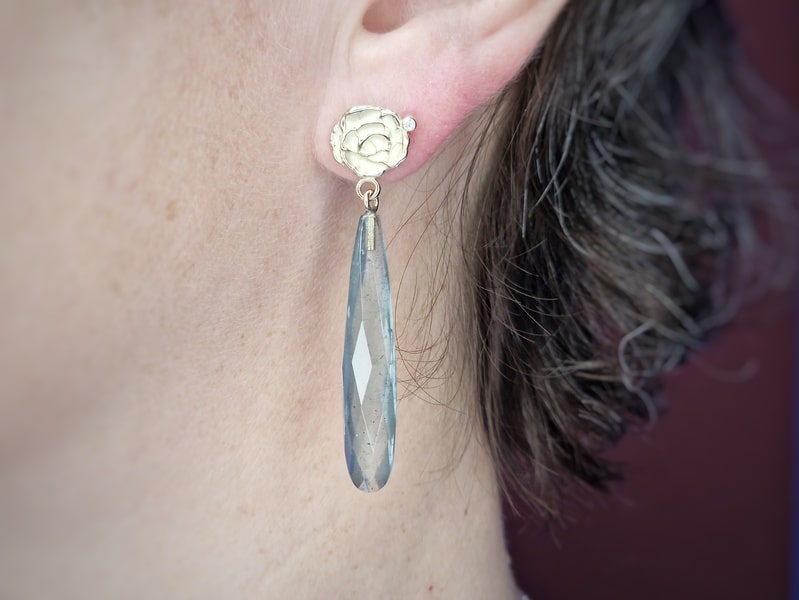 Geelgouden Mackintosh roos oorstekers met briolet mos aquamarijn en diamant. Exclusief paar oorbellen uit het Oogst atelier. In het oor.