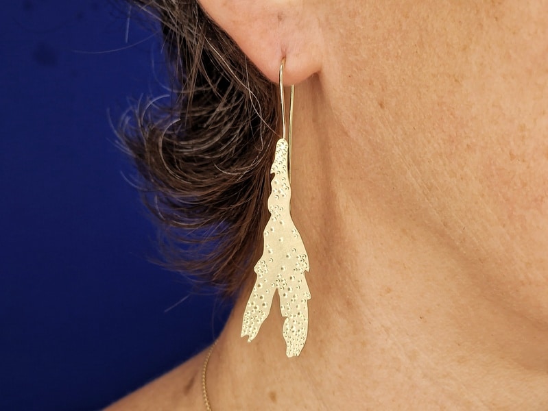 Geelgouden oorhangers Zeewier. In het oor. Ontwerp van Oogst Sieraden in Amsterdam.