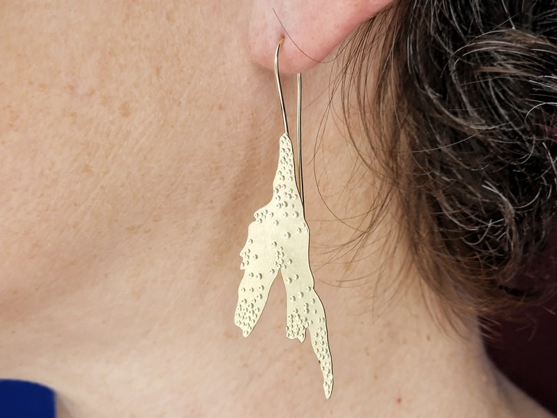 Geelgouden oorhangers Zeewier. In het oor. Ontwerp van Oogst Sieraden in Amsterdam.