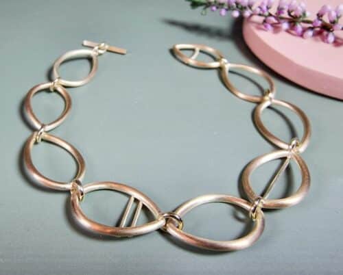 Geelgouden schakel armband opengewerkte Mackintosh ornamenten. Ontwerp van Oogst Goudsmeden in Amsterdam.