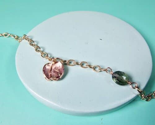 Roodgouden bedel armband met Mackintosh ornament en groene toermalijn. Verfijnd ontwerp van Oogst in Amsterdam