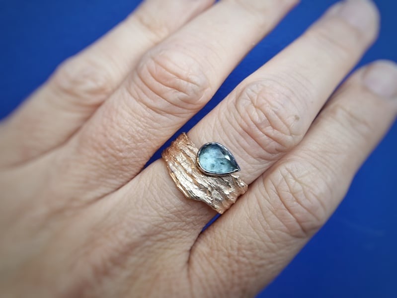 Roségouden ring Rots structuren met mos aquamarijn. Uit de Kust serie. Oogst Goudsmeden in Amsterdam. Om de vinger gedragen.
