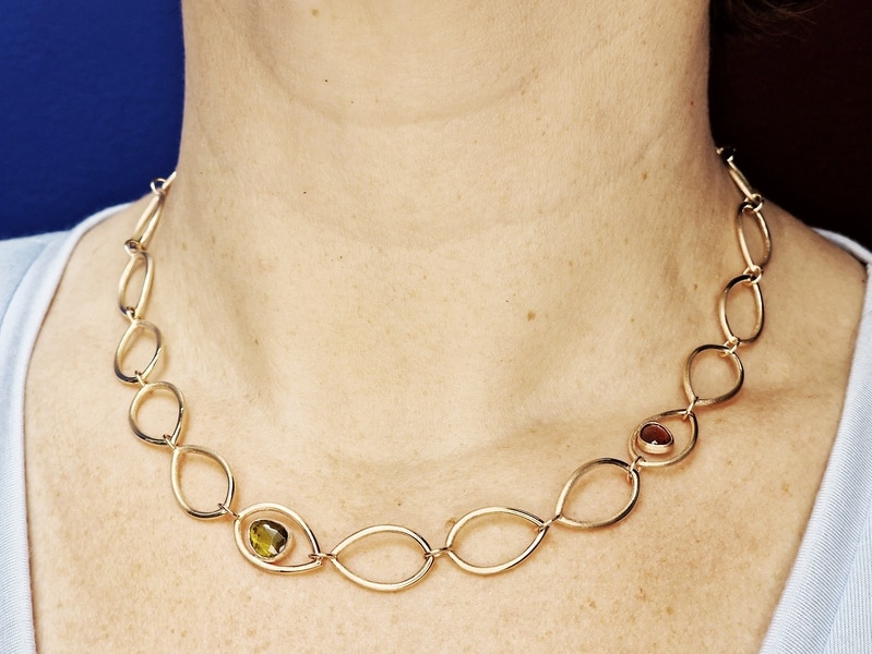 Roségouden schakel collier met open bladvormen, groene toermalijn en roze toermalijn, Mackintosh serie. Ontwerp van Oogst Goudsmeden in Amsterdam. Collier om de hals.