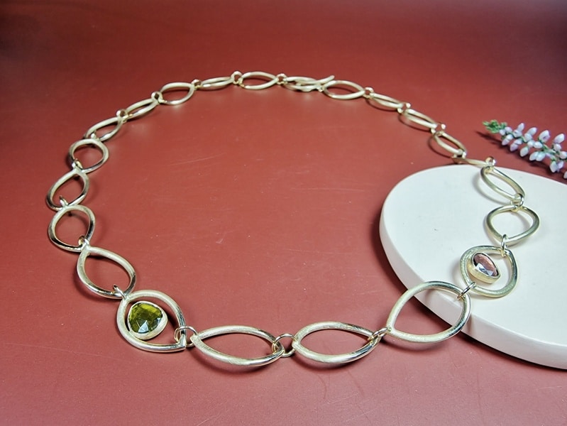 Rosé gold necklace mackintosh with open leaf shapes, green tourmaline and pink tourmaline.