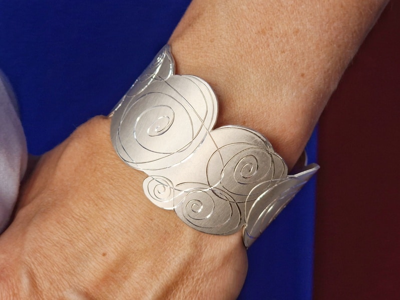 Zilveren klemarmband met rozen handgravure Mackintosh. Uitgesproken ontwerp van Oogst Sieraden in Amsterdam. Om de pols.