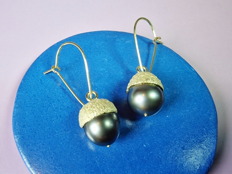 Eik oorbellen. Geelgouden eikendopjes en tahiti parels aan een elegant haakje. Eenmalig ontwerp van Oogst Sieraden in Amsterdam