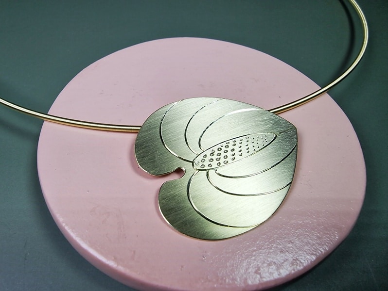 Anthurium hanger. Geelgouden hanger aan geelgouden collier. Detail van de handgravure. Maatwerk uit het Oogst atelier.