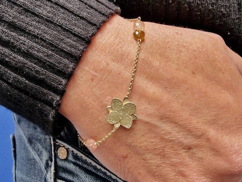 Verfijnde 'In bloei' armband in geelgoud met elegante toermalijn. Om de pols gezien. Sieraad Ontwerp van Oogst Goudsmeden.