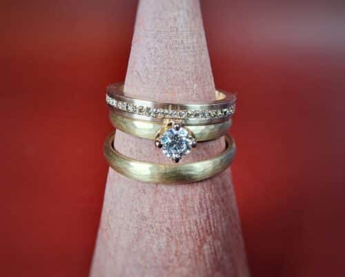 Ritme trouwringen in roségoud met streepjes hamerslag en een Eenvoud ring met diamanten rondom. Bijzondere trouwringen uit het Oogst atelier.
