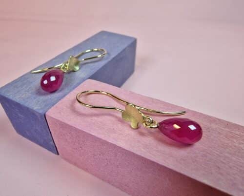 Gouden bloem oorbellen met robijn. Uit de In Bloei serie van Oogst Sieraden in Amsterdam