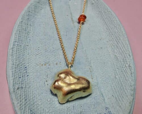 Gouden collier met hanger Wolk en een accent van carneool. Speels ontwerp van Oogst Goudsmeden.