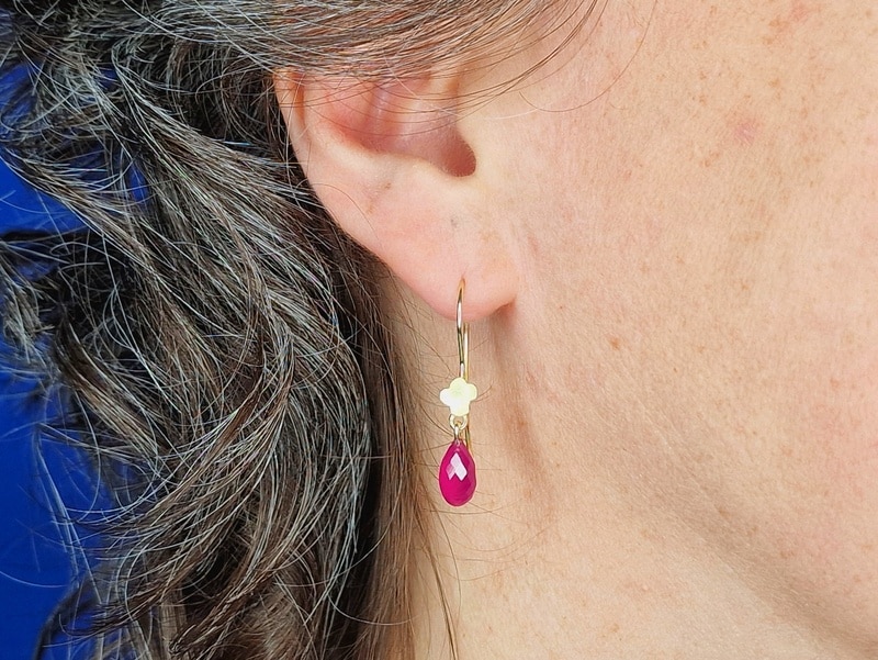 Gouden bloem oorbellen met robijn. Uit de In Bloei serie van Oogst Sieraden in Amsterdam. Oorbel in het oor te zien.