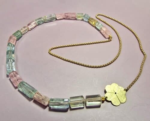 Geelgouden collier 'Japonais' met vrolijke beryl kristallen, morganiet & aquamarijn en een geelgouden bloesem. Uit het Oogst atelier.